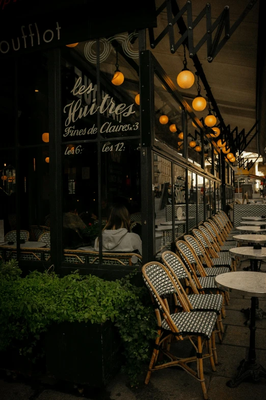 tables and chairs outside a restaurant lit up