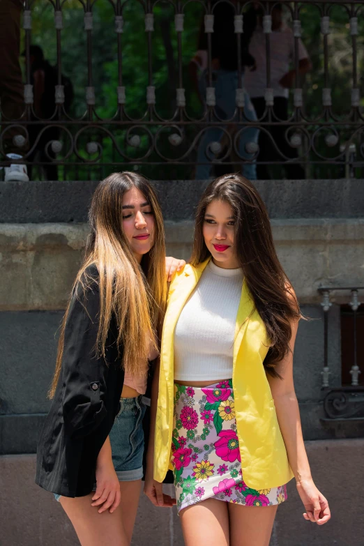 two beautiful young women standing next to each other