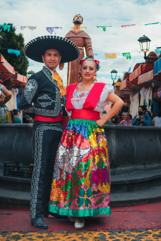 a couple posing in mexican costumes at the festival