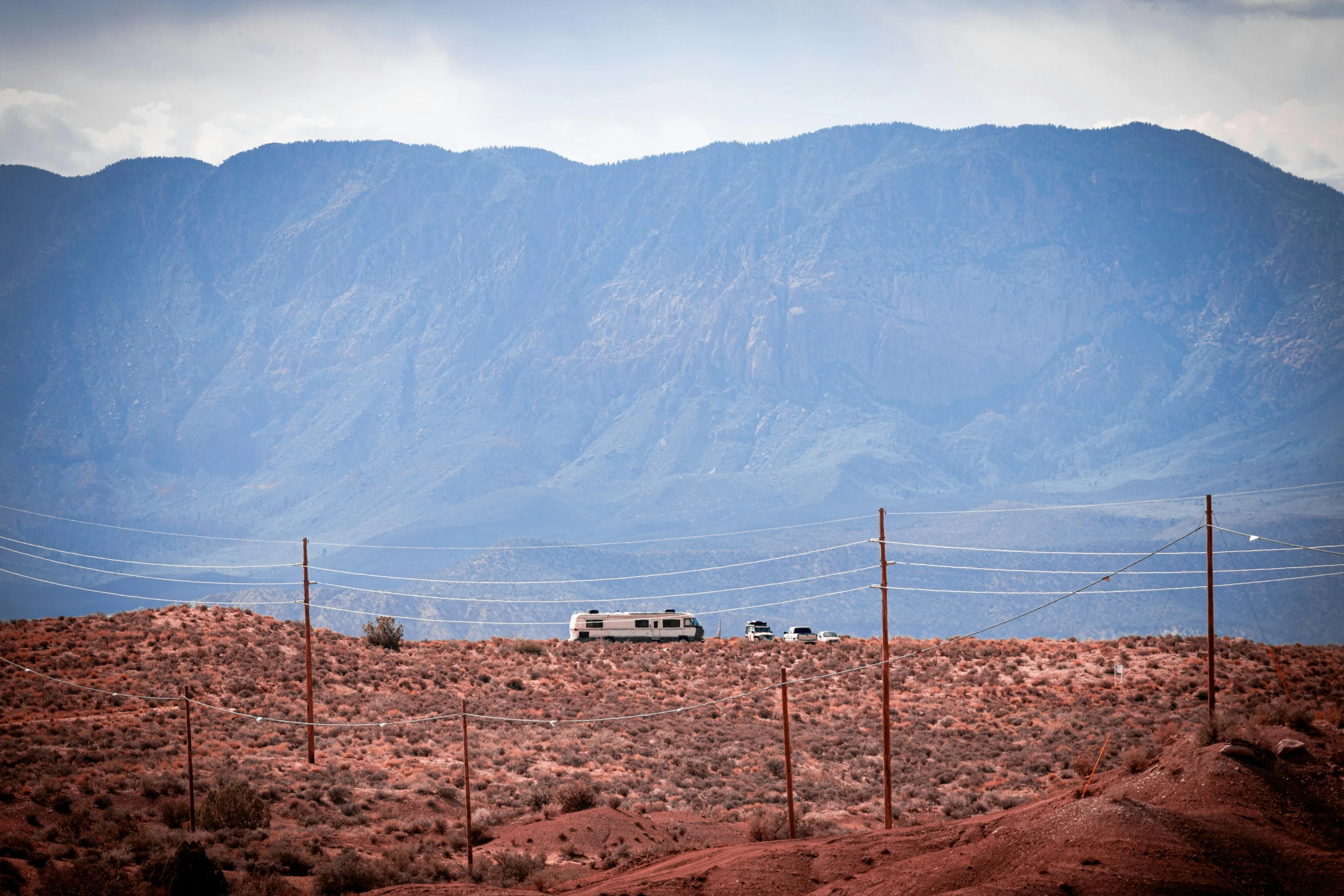 a group of cars are parked along the roadside of a mountain