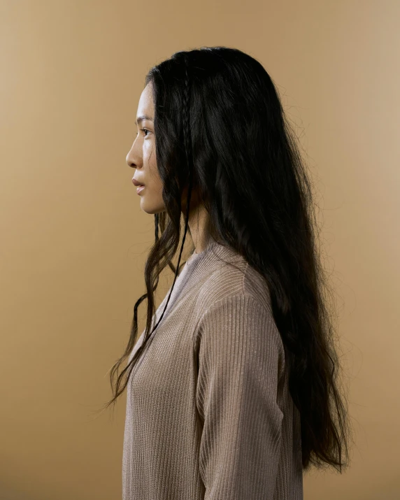 a woman in a tan top with a long black hair