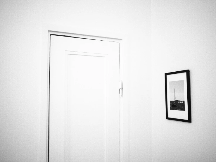 a white room with an open door and pictures on the wall