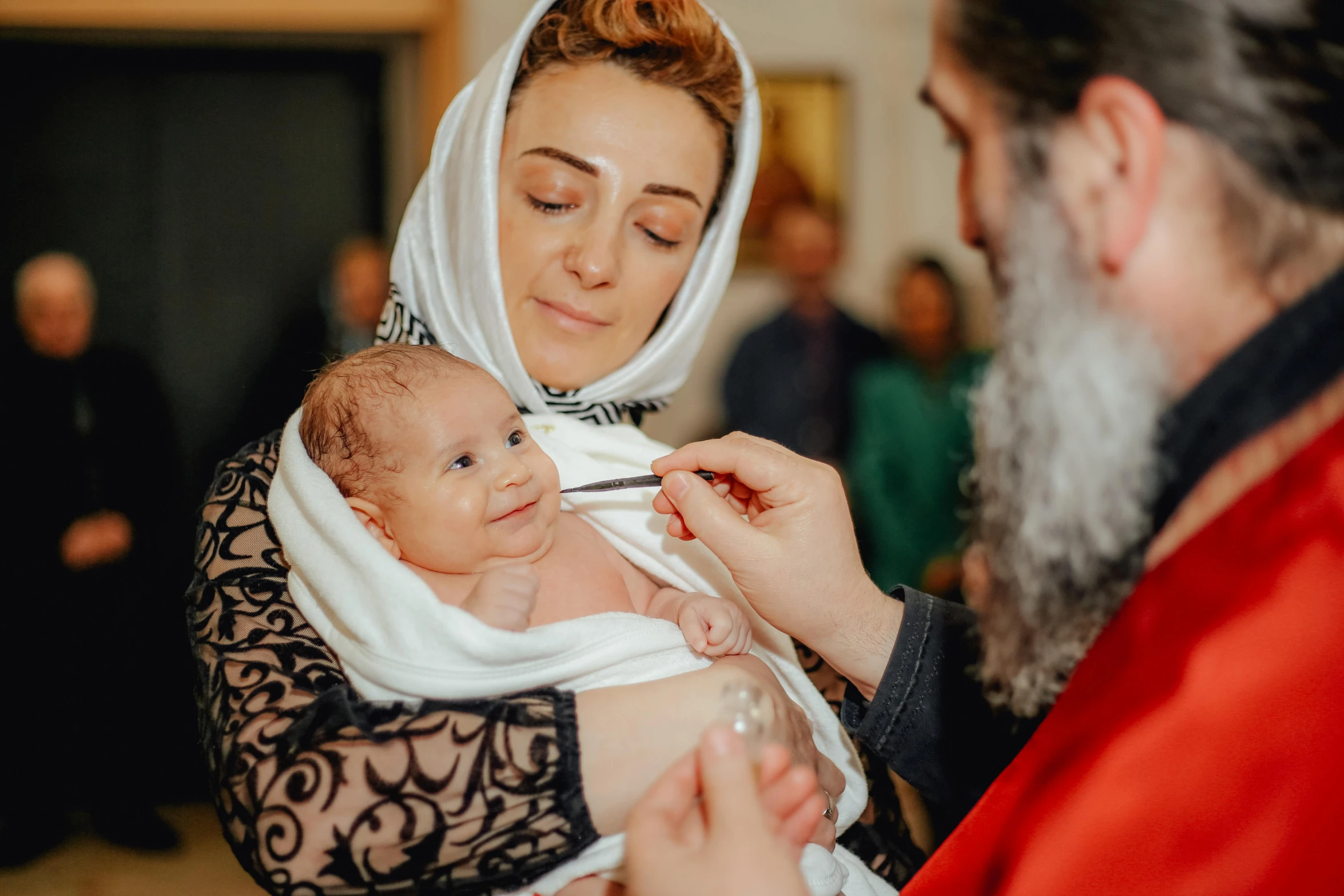 a woman in a black dress holds a baby in her arms