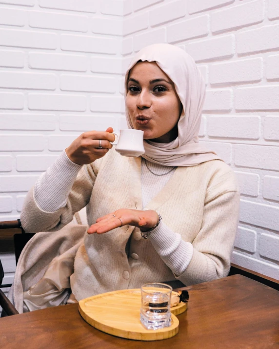 a beautiful young woman in a hijab eating food from a tray