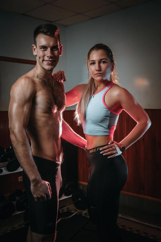 a young man and woman pose in front of a mirror