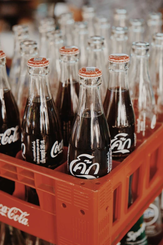 six bottles of coca cola lined up in a crate