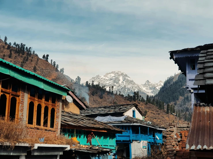 houses sitting in the hills behind a mountain range