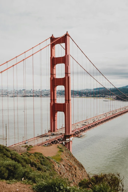 the view from a hill looking down at the golden gate bridge