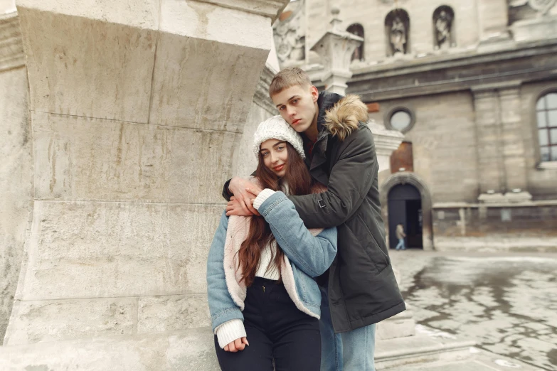 the couple is posing outside next to a building