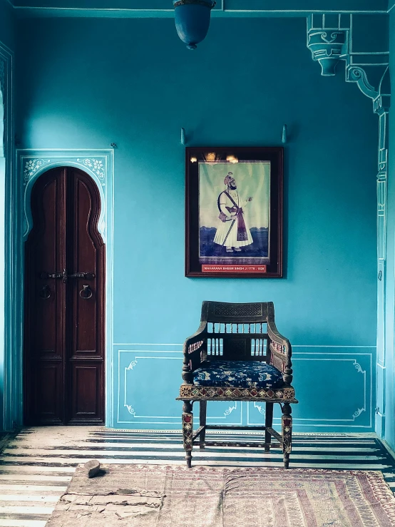 a large chair sitting in front of a blue wall