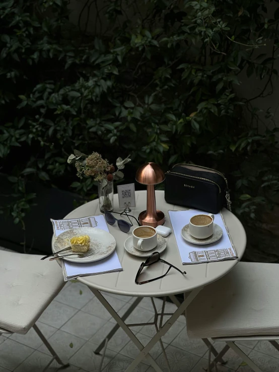 a dinner set out on a small table in front of trees