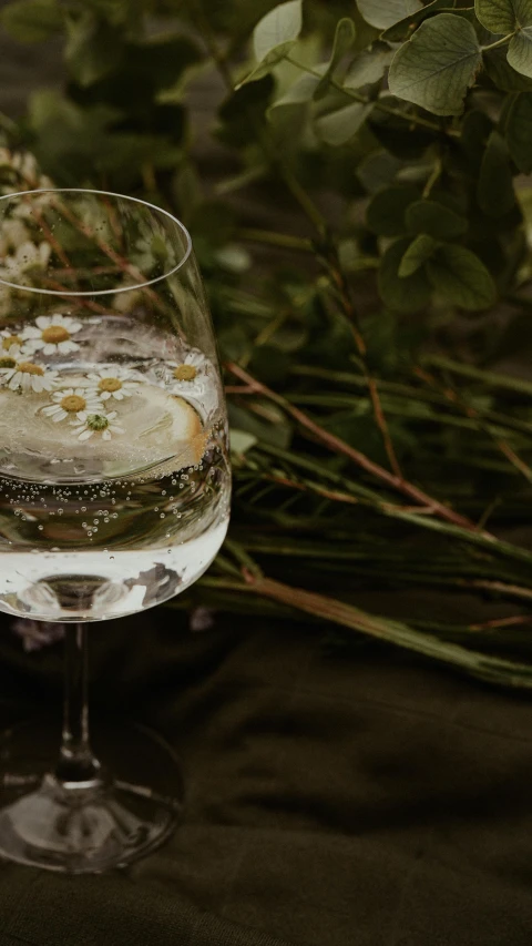 the wine glass is full of wine and some flowers