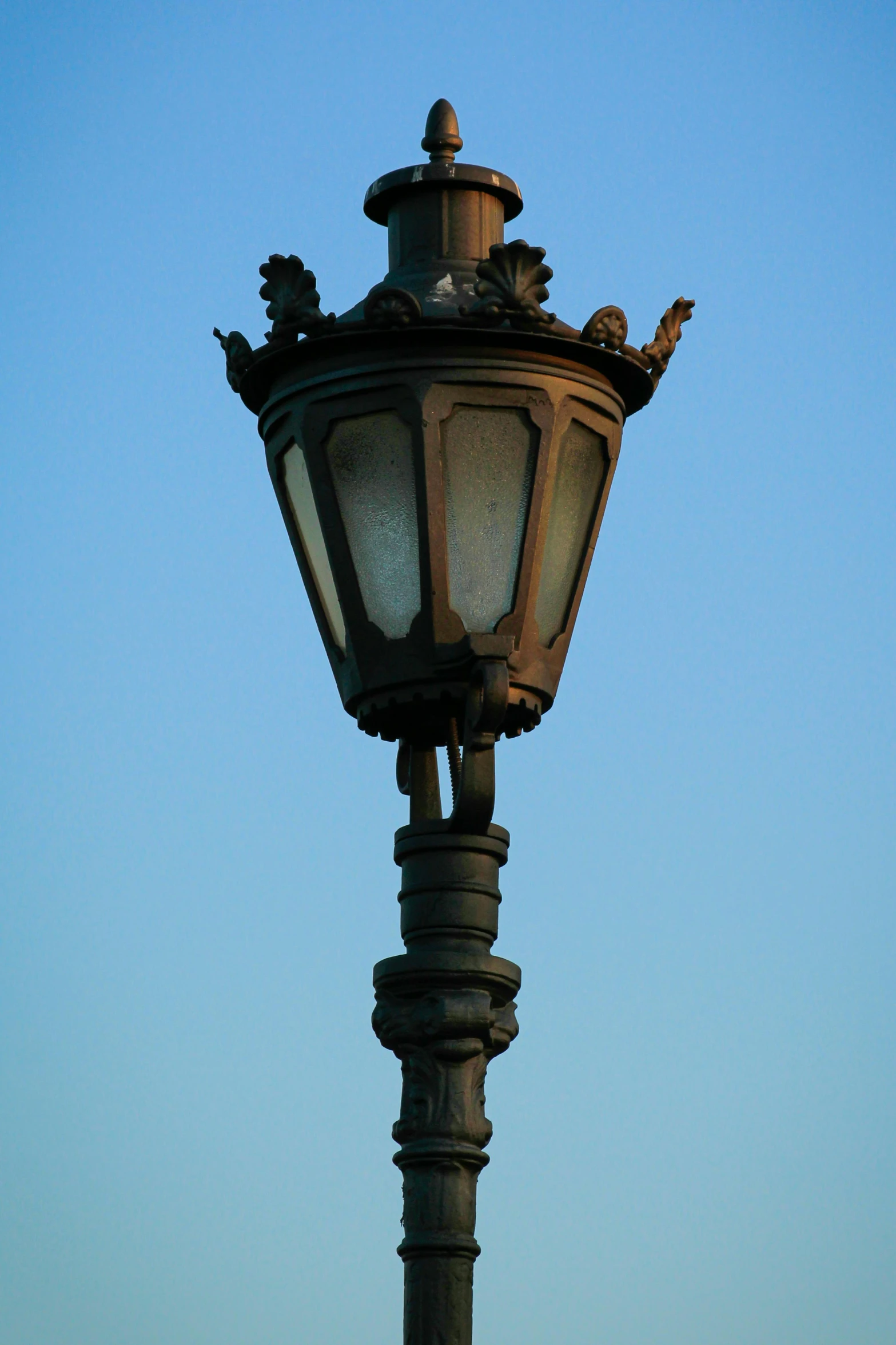 there is a old - fashioned street lamp that is lit against the sky