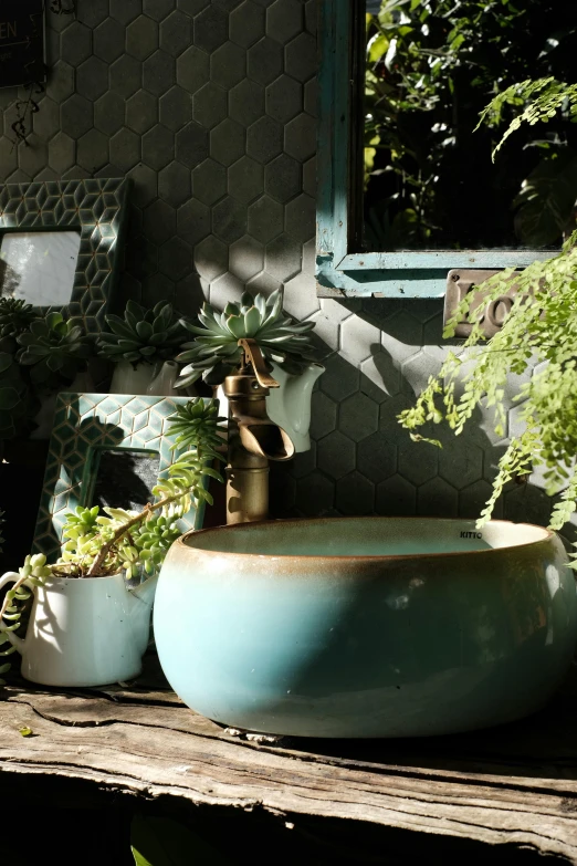 the bowl sink is made out of clay with a metal faucet and a mirror in front of it