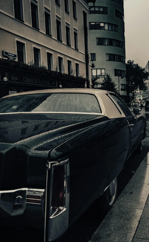 two cars are stopped on a busy street as the rain begins to fall