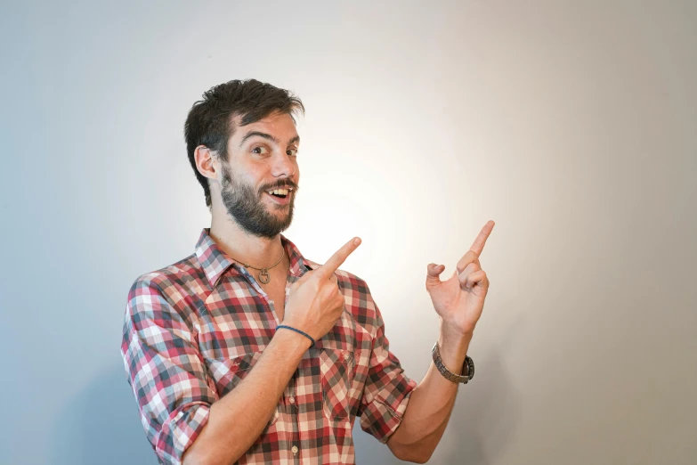 a man in plaid shirt pointing at soing