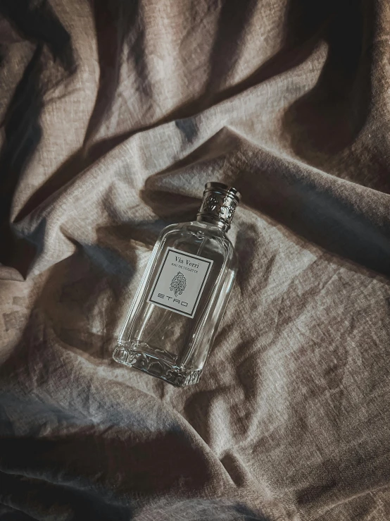 an empty glass bottle on a brown blanket