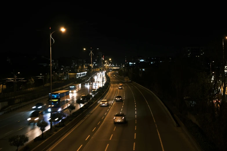 a nighttime street scene with a large number of cars on the road