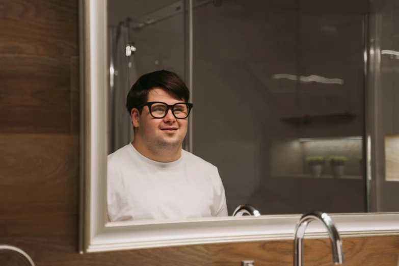 a young man is smiling in the mirror in the bathroom