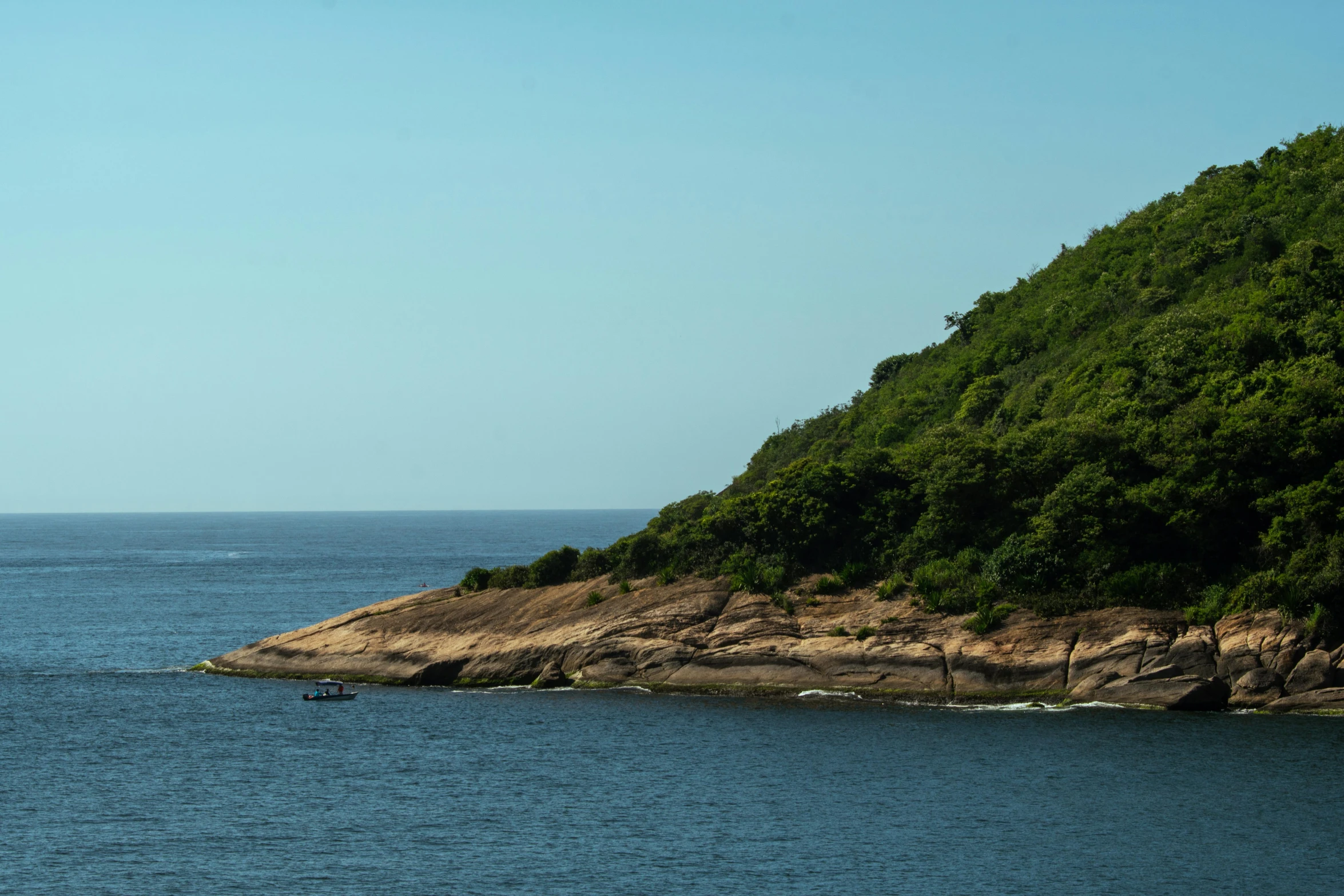 the sailboat is heading toward the shore of an island