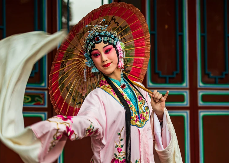 a woman dressed in a chinese costume holding a parasol