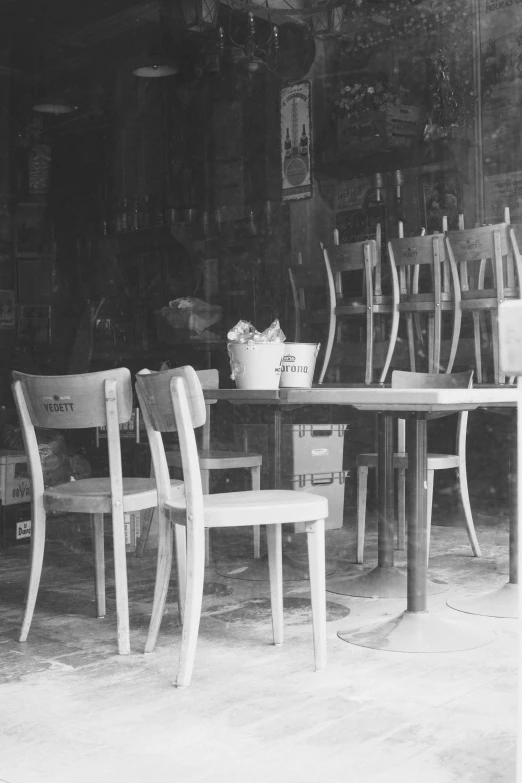 three chairs around a table in front of a store