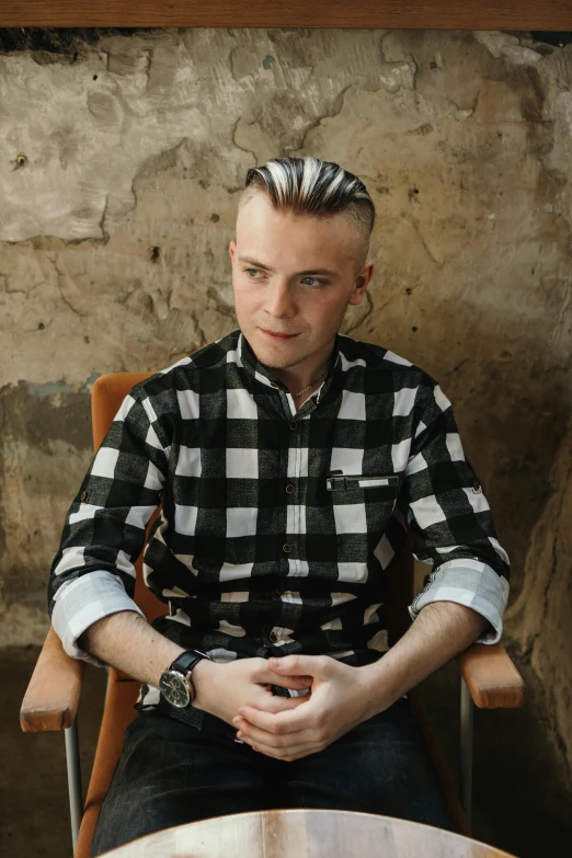 a man with a mohawk sitting down in a chair