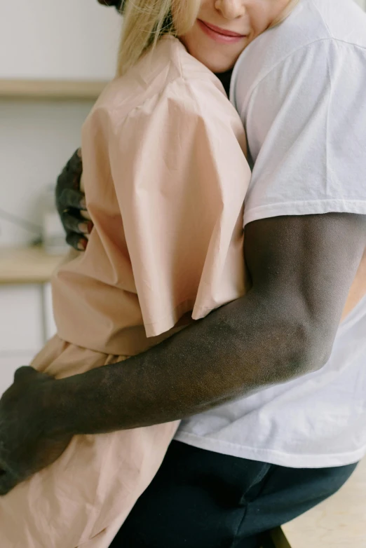 a couple of people hugging each other while standing