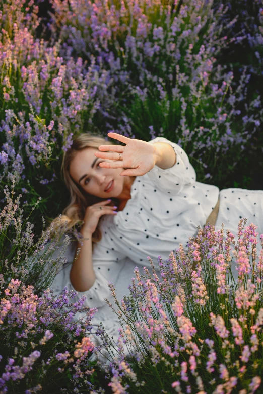 girl lying in flowers in white dress posing for the camera