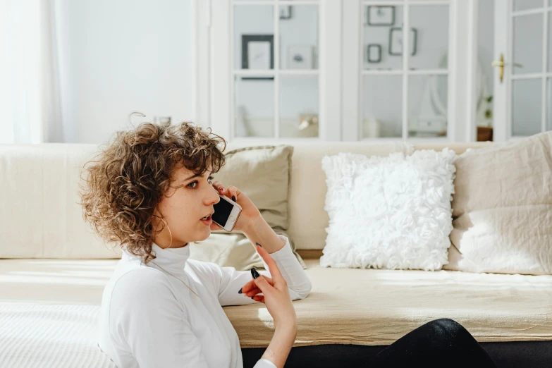 a young woman holding a cellphone to her ear