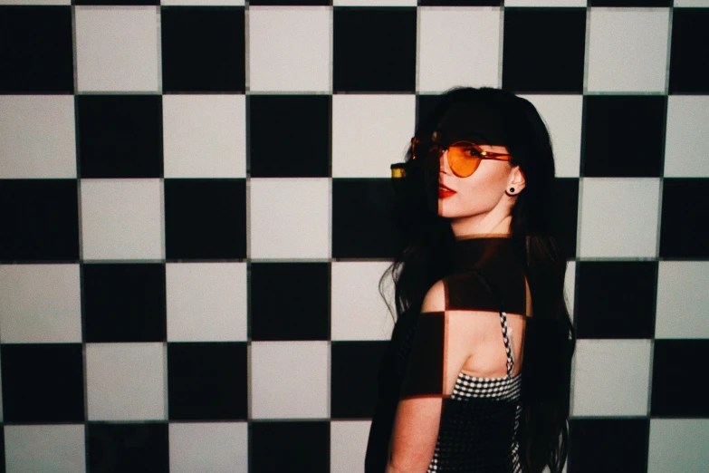 woman in sunglasses posing for po in black and white tile room