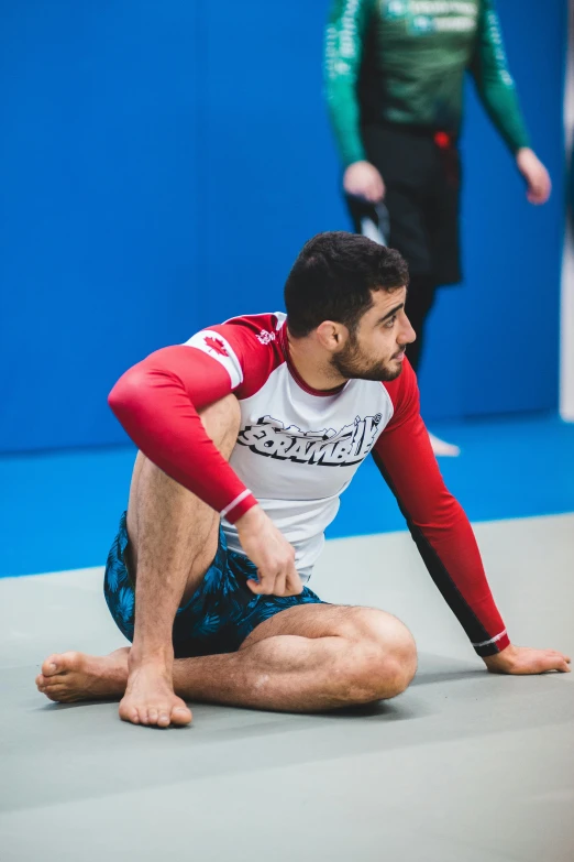 a man in red and white shirt wrestling in competition