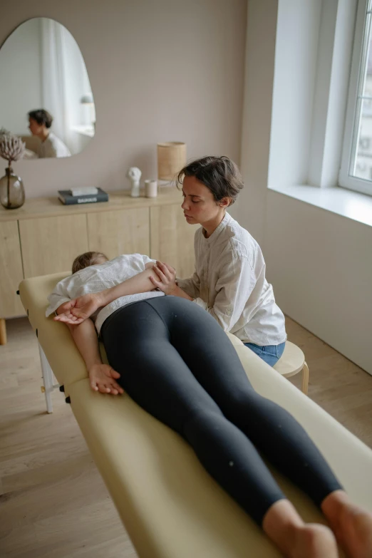 woman with dark hair sitting down having a facial massage