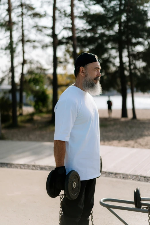 a man holding his skate board on a sidewalk