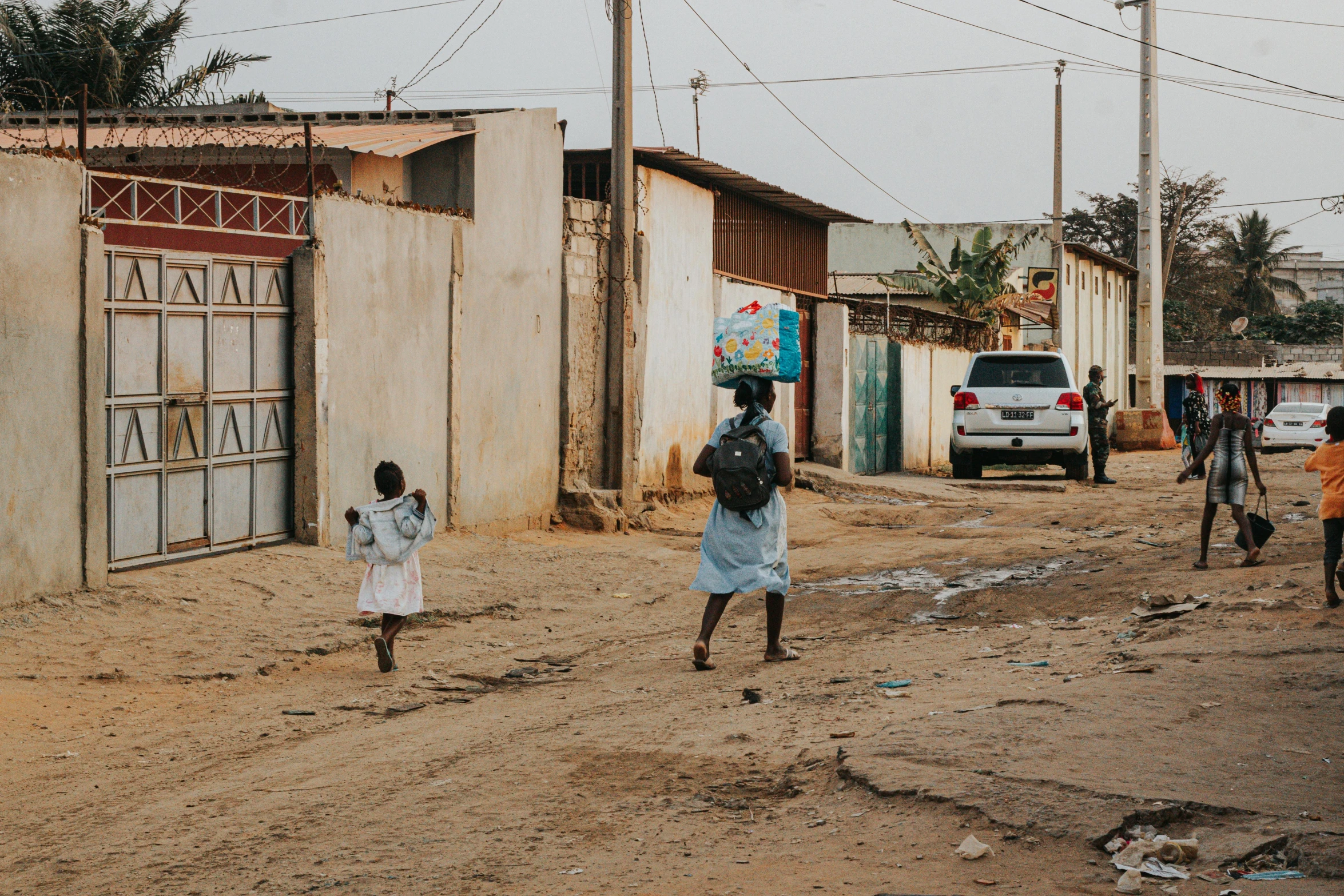 children playing soccer on dirt field near building