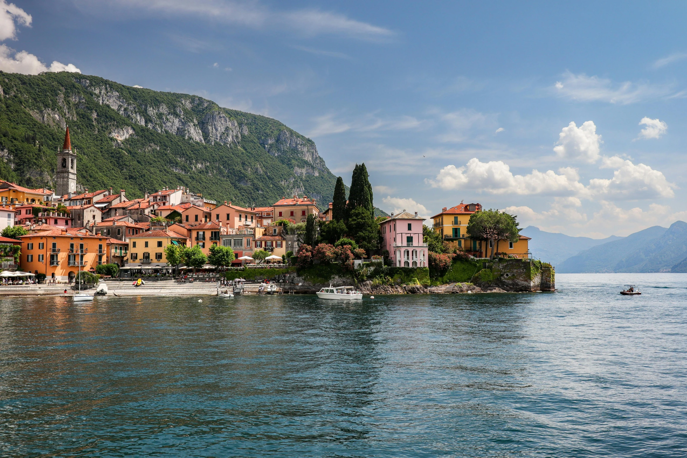 a picturesque village is shown on a cliff above a lake