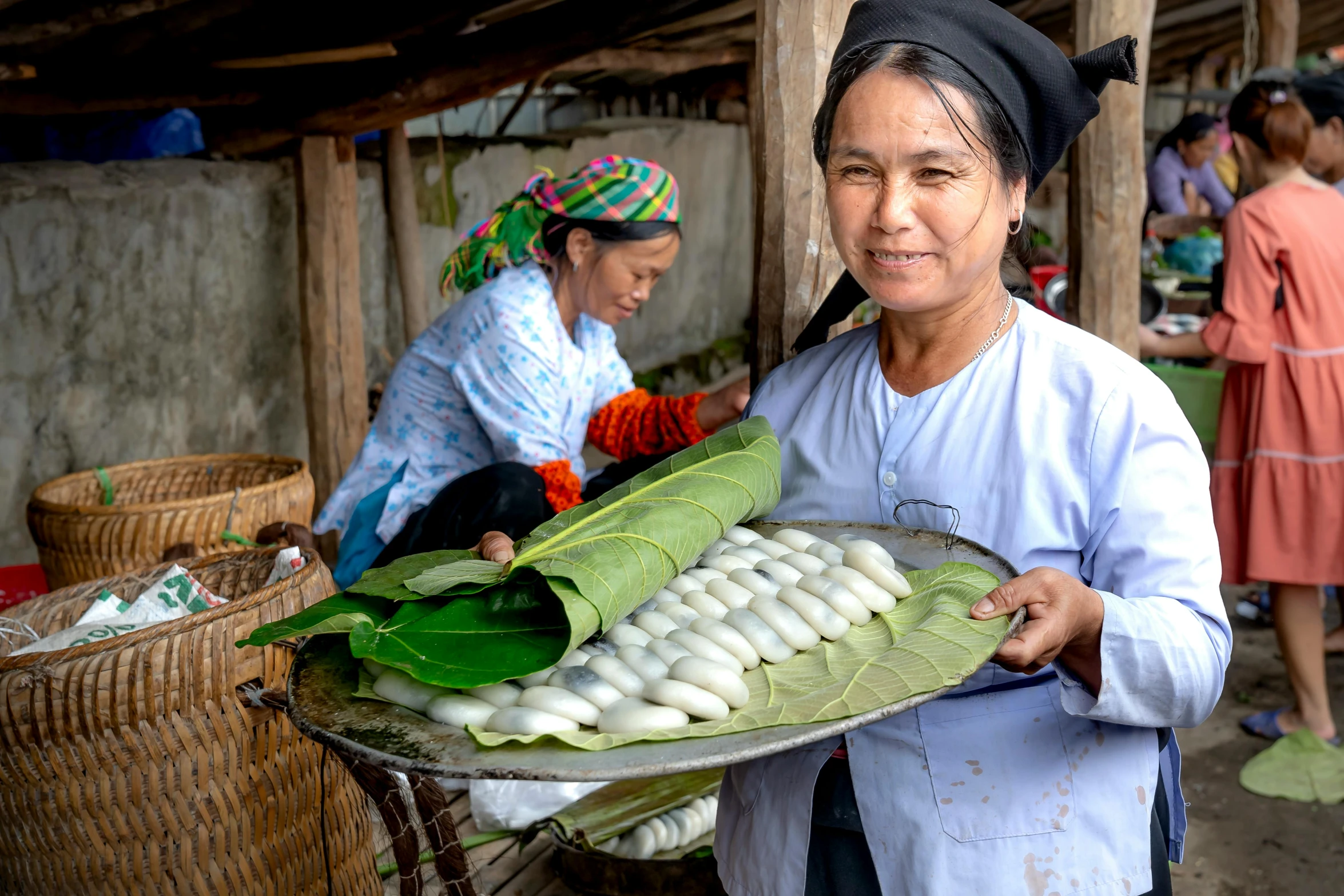 a lady is holding some trays of vegetables