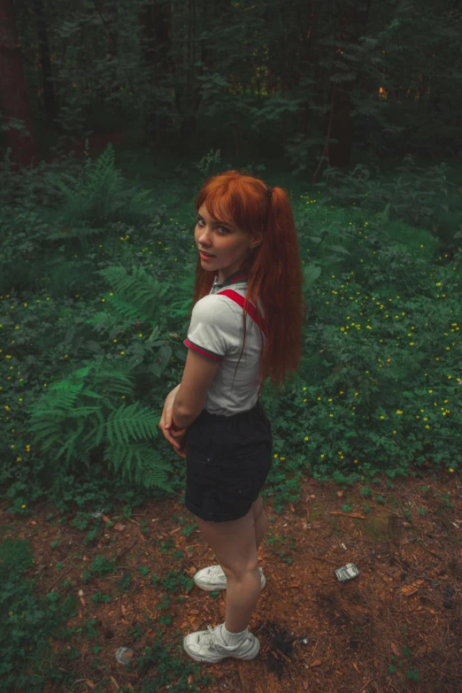 a young woman with red hair and shorts in the woods