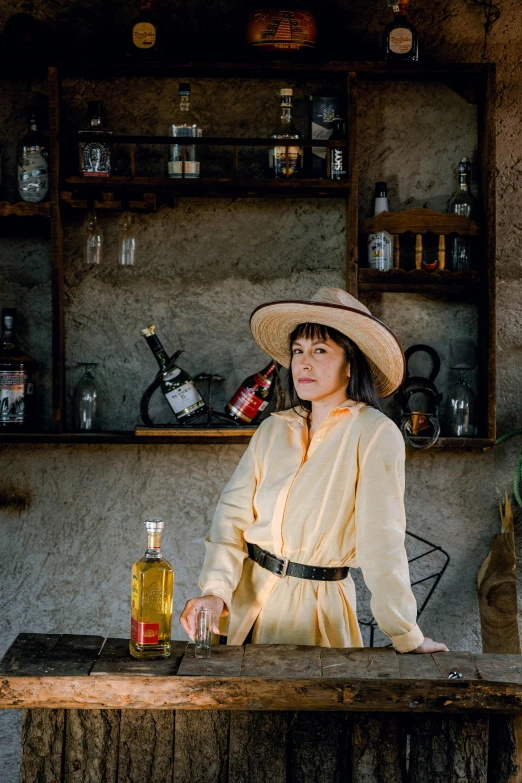 a woman in an outfit and hat sits at a bar