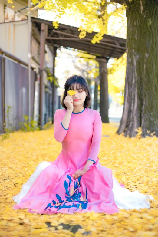 woman in a pink gown on the phone while outside