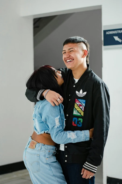 a young couple hug each other and smile