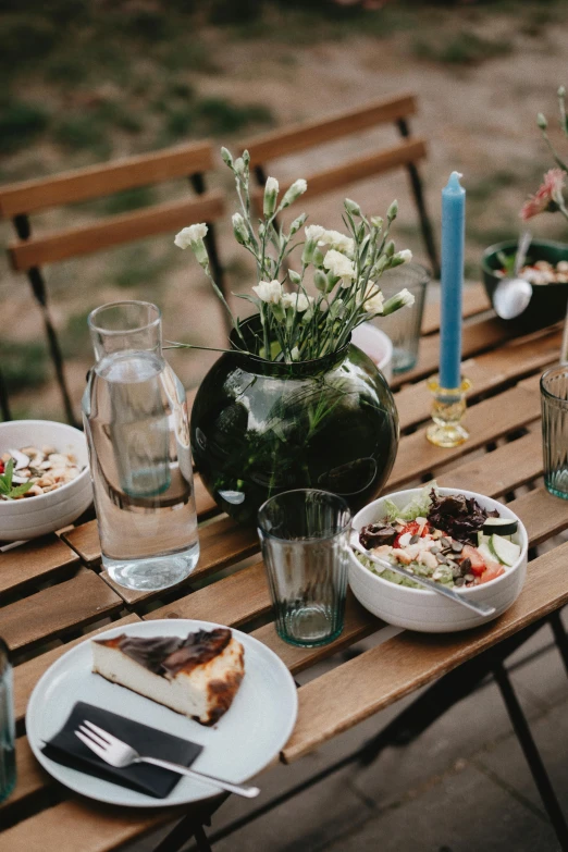 an empty wooden table with dishes and vases on it