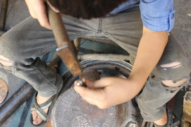 a person with a hammer standing in a bowl holding soing