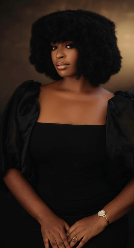 a woman wearing a black dress in front of a gray background