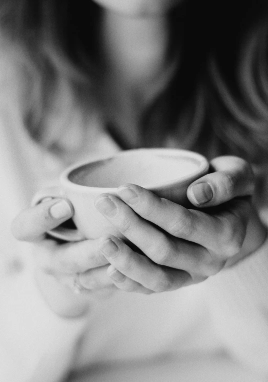 a black and white po of a woman holding a cup