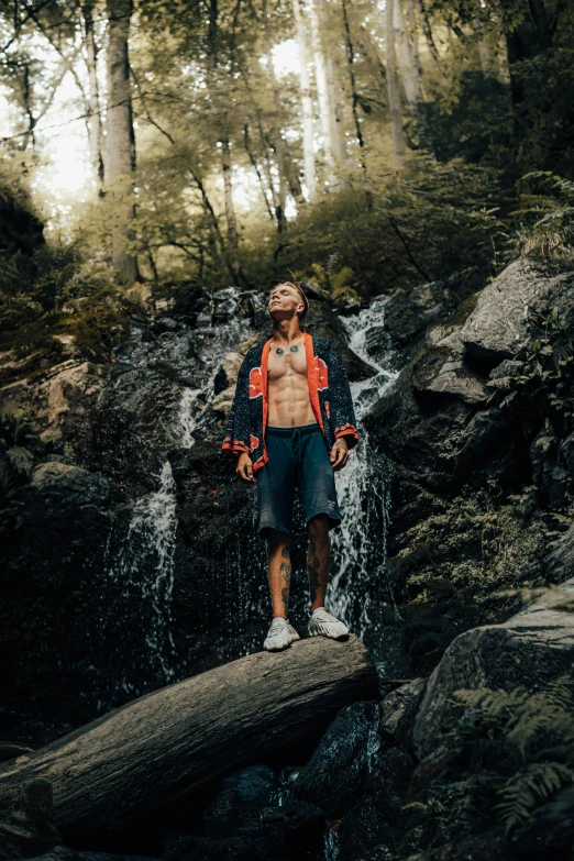 the man stands on the edge of a fallen log near the water