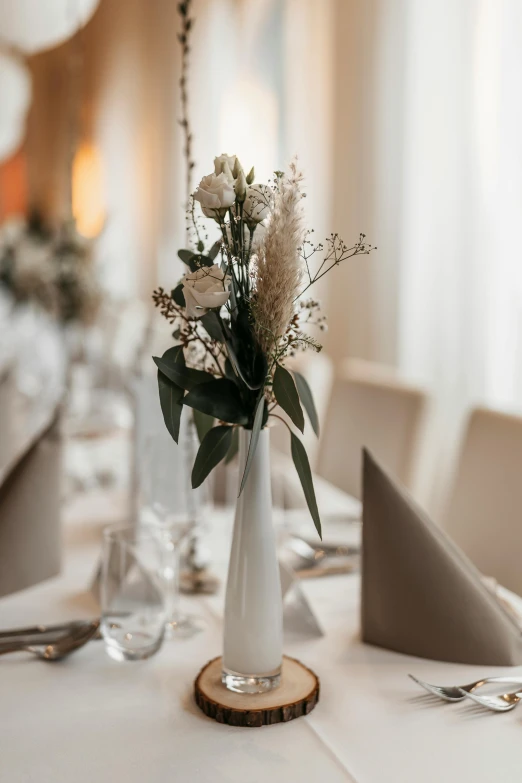 the centerpieces of this table are simple vases with flowers