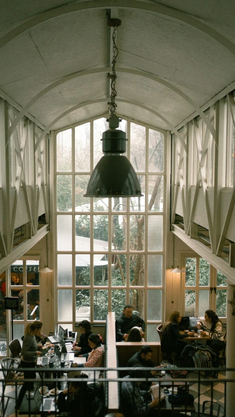 the room has large windows and tables with chairs