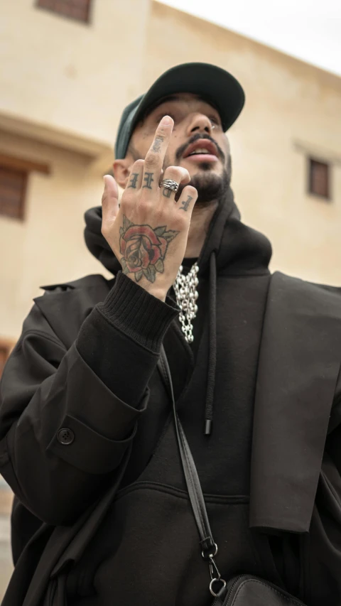 a man with tattoos holds his hand in the air