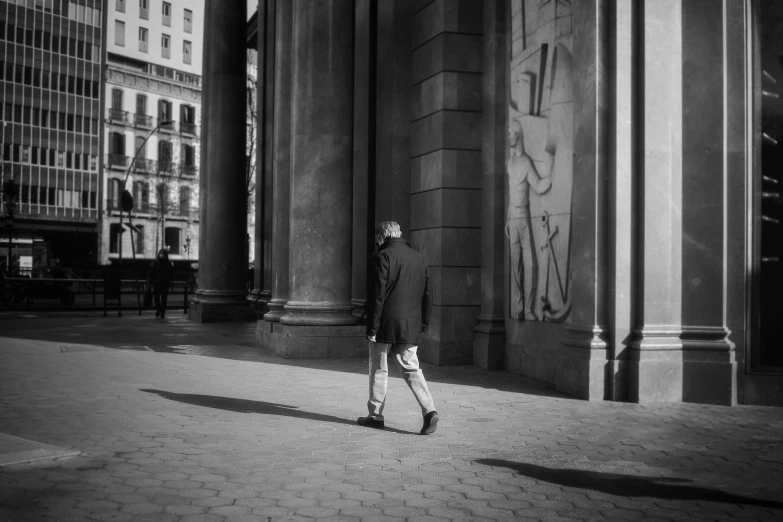 a man in a suit is walking down a city street